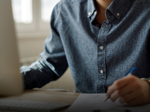 An interested Acura buyer researching the Acura Standard Warranty package on his computer at home. // Un acheteur Acura intéressé à la recherche de l'ensemble de garantie Acura de série sur son ordinateur à la maison